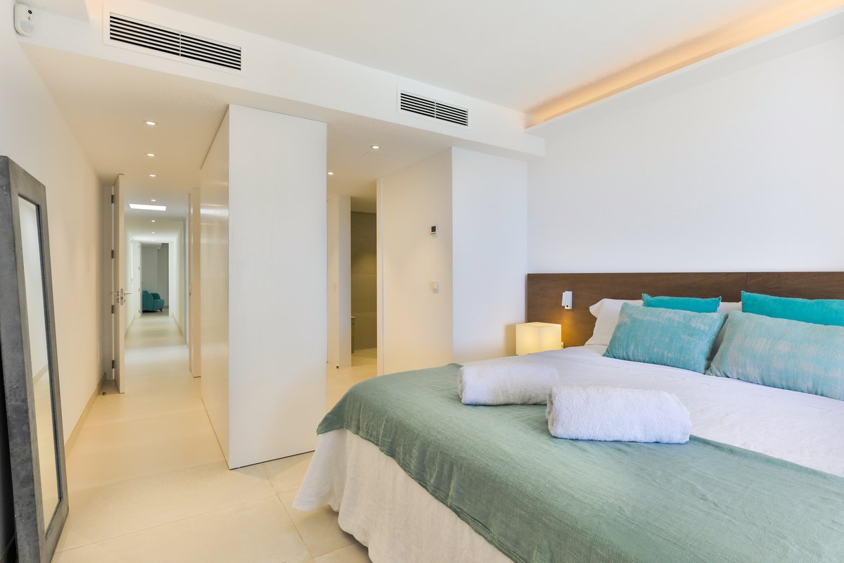 A bedroom with a large bed and blue pillows