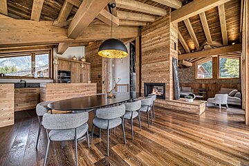 A dining room with a table and chairs and a fireplace