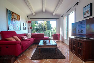 A living room with a red couch and a flat screen tv