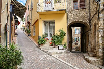 A yellow building with a balcony and a sign that says ' boutique ' on it