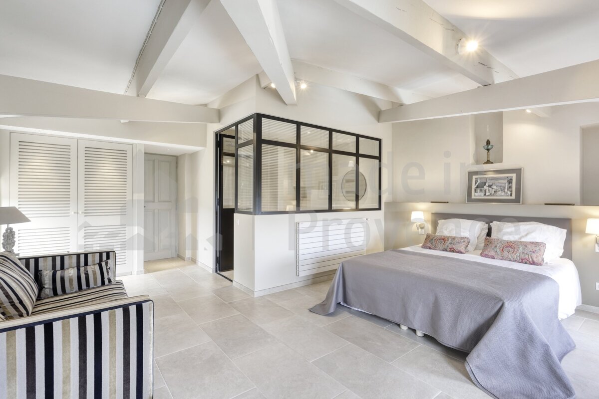 A bedroom with a large bed and a striped couch