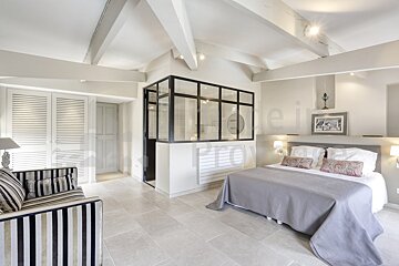 A bedroom with a large bed and a striped couch