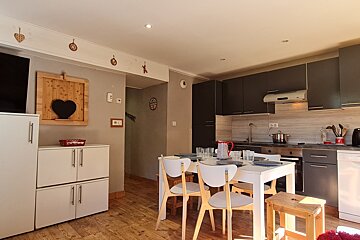 A kitchen with a table and chairs and a heart on the wall
