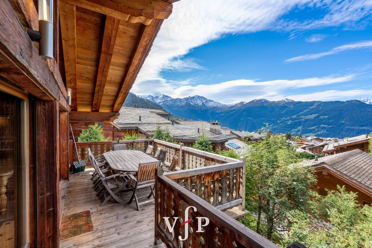 A wooden balcony with a table and chairs and a sign that says vjp