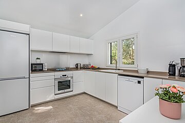 A kitchen with white cabinets and a lg refrigerator