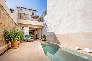 A small swimming pool in the backyard of a house