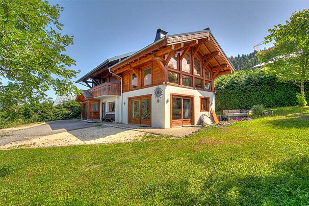 A large house with a lot of windows is surrounded by trees