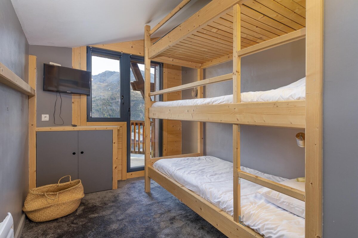 A bedroom with bunk beds and a flat screen tv