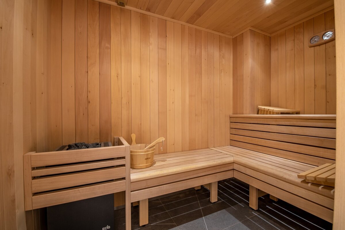 A wooden sauna with a wooden bucket on the bench
