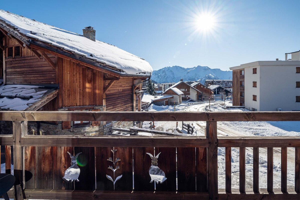 A balcony with a view of a snowy village and mountains