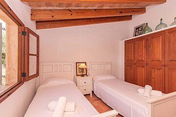 A bedroom with two twin beds and wooden cabinets