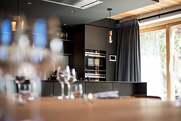 A kitchen with black cabinets and a large window