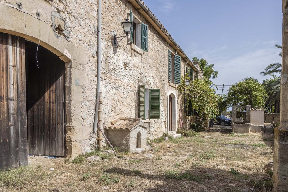 An old stone building with green shutters on the windows