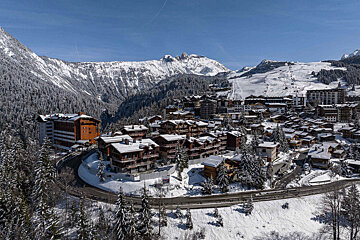 A snowy landscape with a mountain in the background