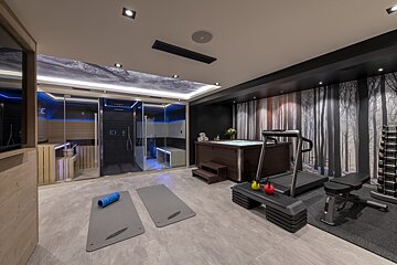 A gym with a treadmill and a hot tub