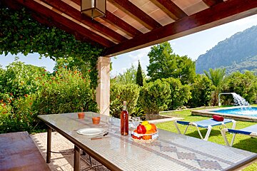 A table with a bowl of fruit and a bottle of wine on it