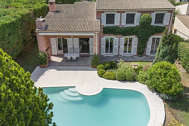 A large house with a swimming pool in front of it