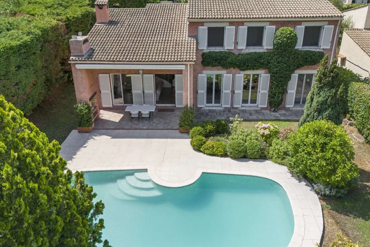 A large house with a swimming pool in front of it