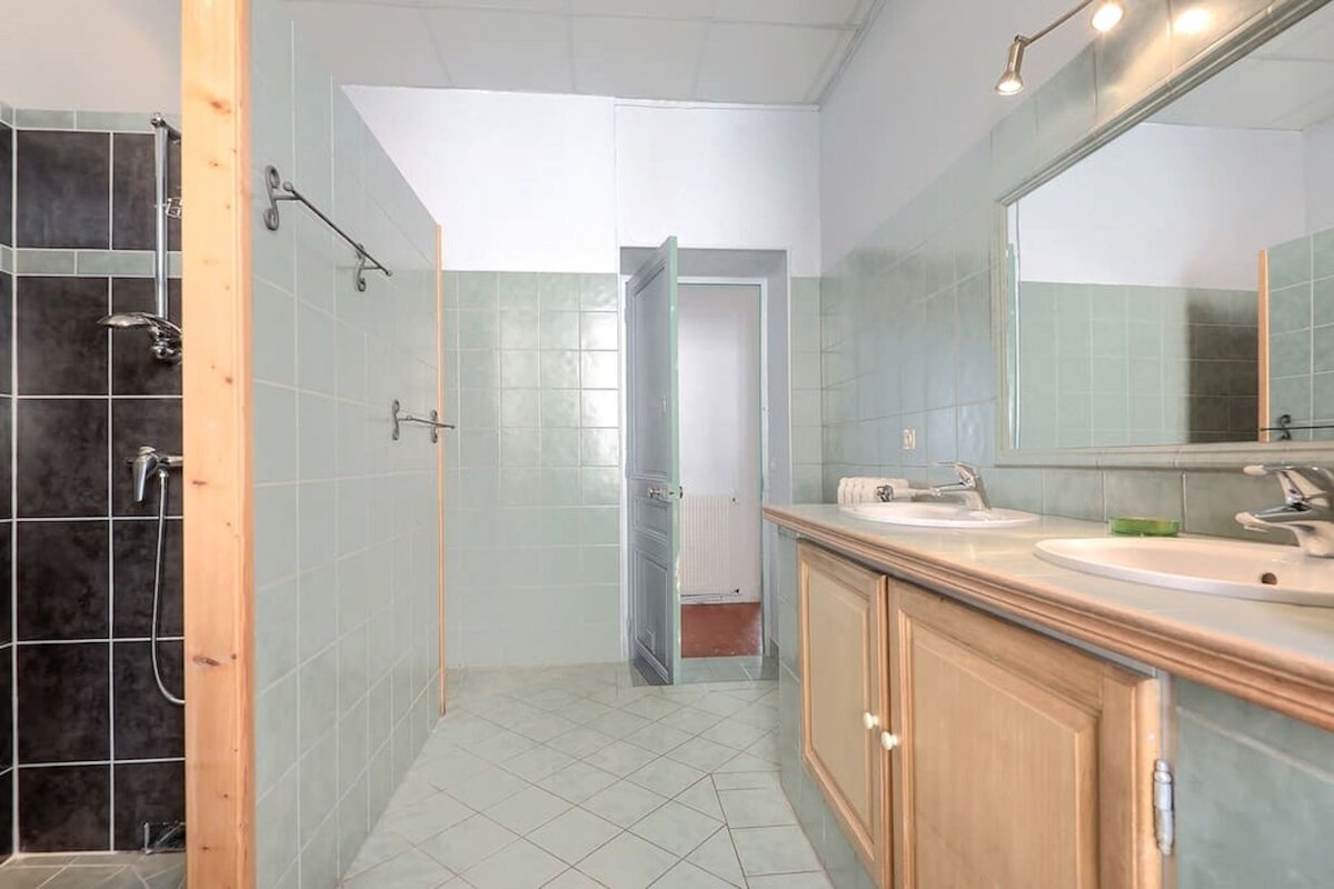 A bathroom with two sinks and a walk in shower