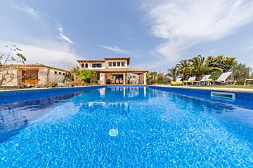 A large swimming pool with a house in the background