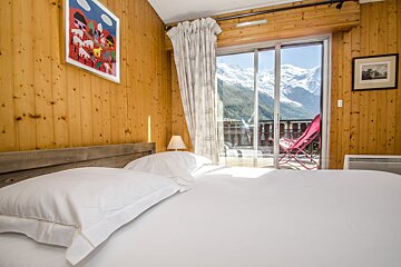 A bedroom with a sliding glass door leading to a balcony