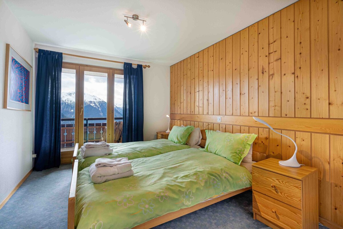 A bedroom with two beds and a nightstand