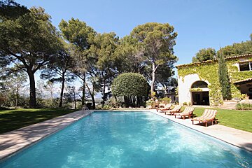 A large swimming pool surrounded by chairs and trees