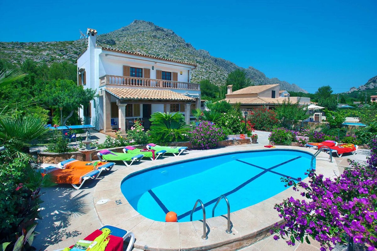 A house with a large swimming pool in front of it