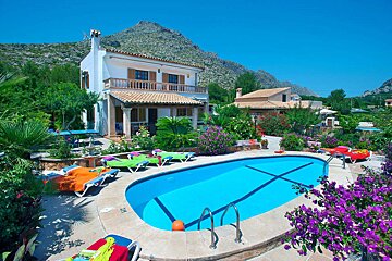 A house with a large swimming pool in front of it