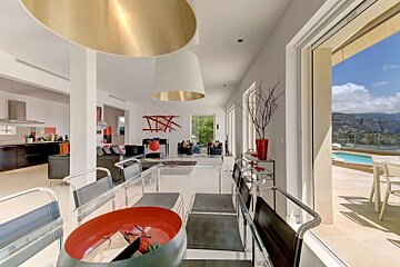 A dining room table with a red bowl on it