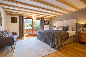 A bedroom with a large bed and a couch