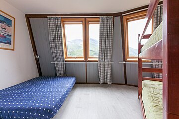 A bedroom with a bunk bed and a picture on the wall