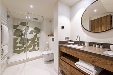 A bathroom with a toilet a sink and a mirror