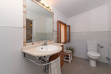 A bathroom with a sink toilet and mirror
