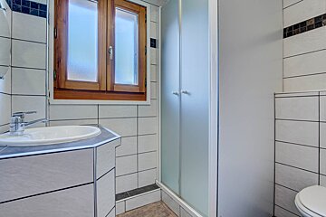 A bathroom with a sink and toilet and a window