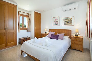 A bedroom with a purple pillow on the bed