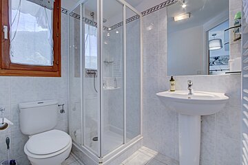 A bathroom with a toilet a sink and a shower