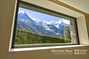 A window with a view of the mountains and the words mountain base knight frank