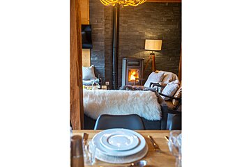 A table with plates and silverware in front of a fireplace