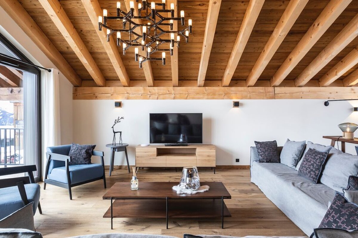 A living room with a wooden ceiling and a flat screen tv