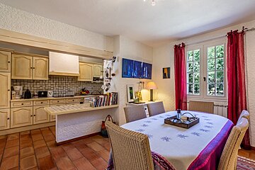 A kitchen with a table and chairs and a painting on the wall