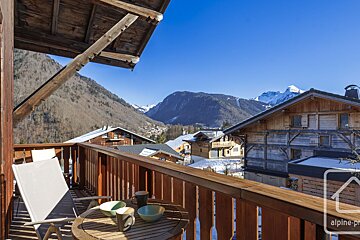 A balcony with a view of mountains and a sign that says alpine-pro