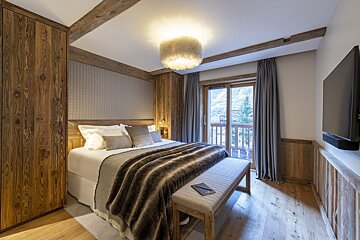 A bedroom with a large bed and a flat screen tv