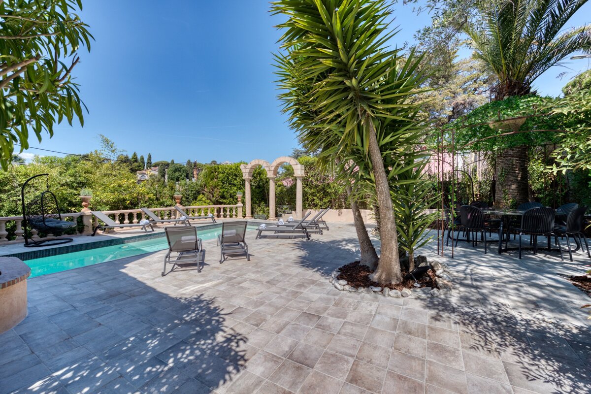 A patio area with a swimming pool and chairs