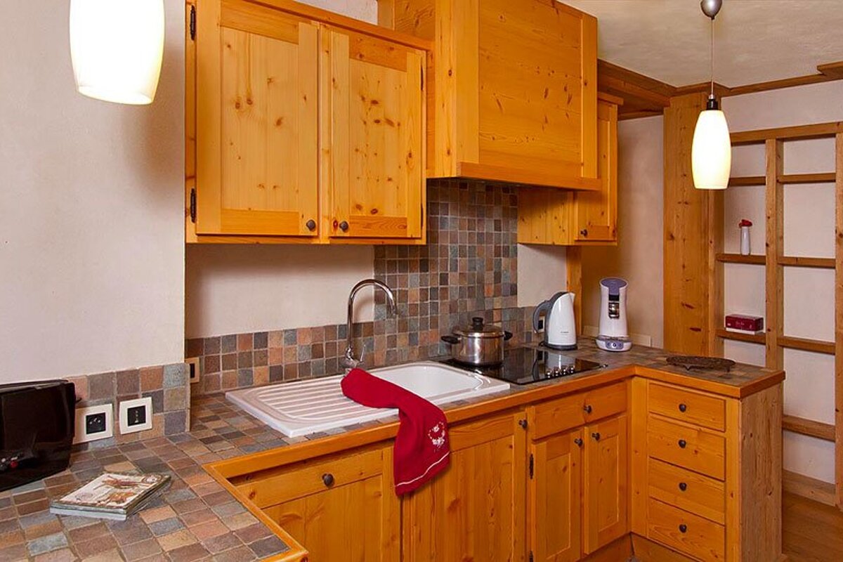 A kitchen with wooden cabinets and a stove top oven