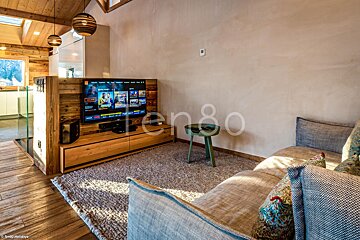 A living room with a couch and a television with the number 80 on the wall