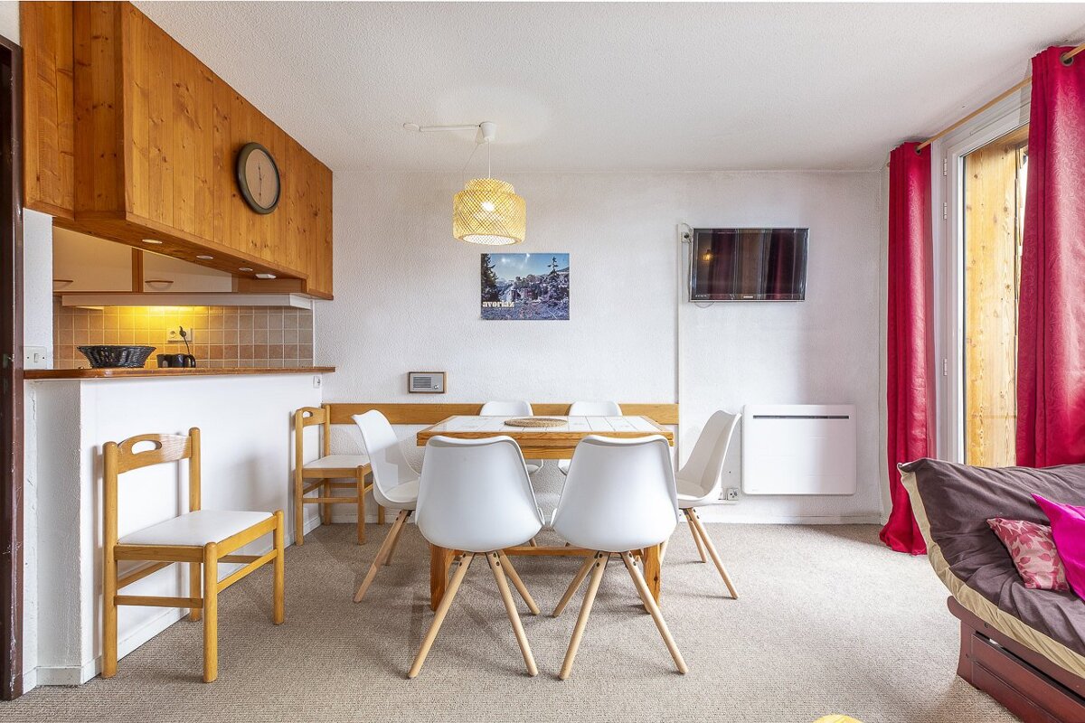 A dining room with a table and chairs and a picture on the wall