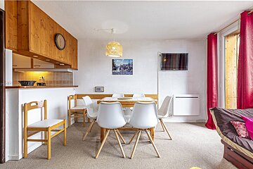 A dining room with a table and chairs and a picture on the wall