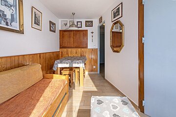 A hallway with a couch a table and a mirror