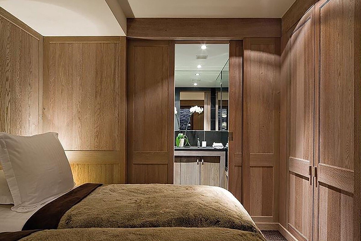 A bedroom with a sliding door that leads to a bathroom